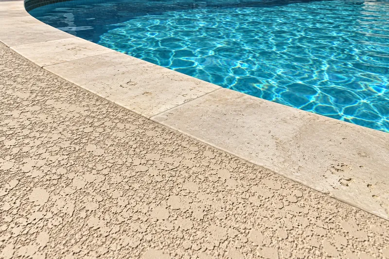 Close view of a light knockdown deck topping at the pool edge