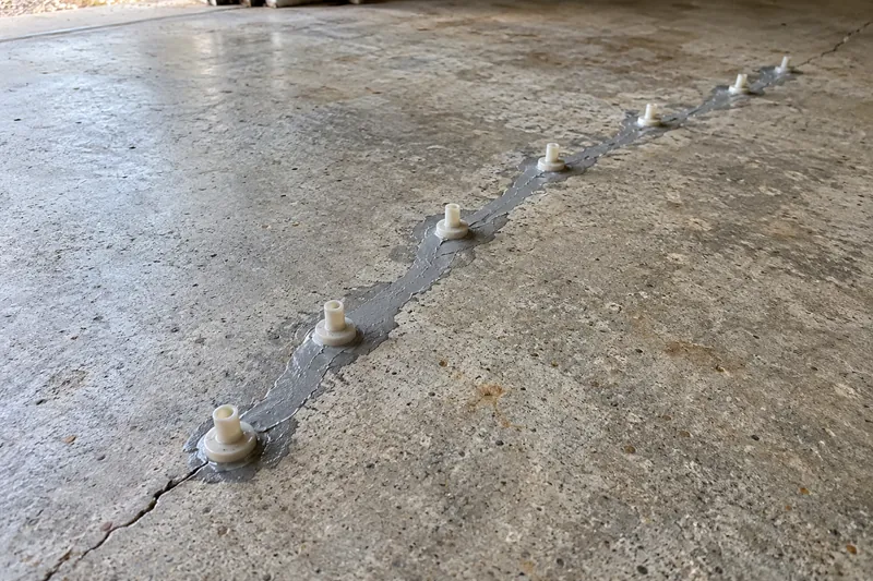 Epoxy injection ports set along a sealed slab crack