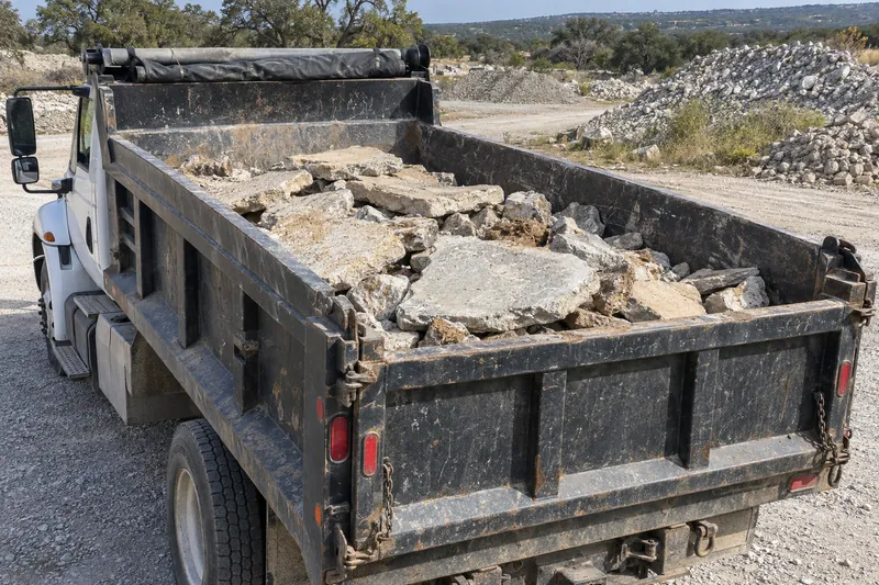 Dump truck bed loaded with broken concrete slabs