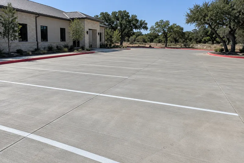 Empty new concrete parking lot with white stall lines