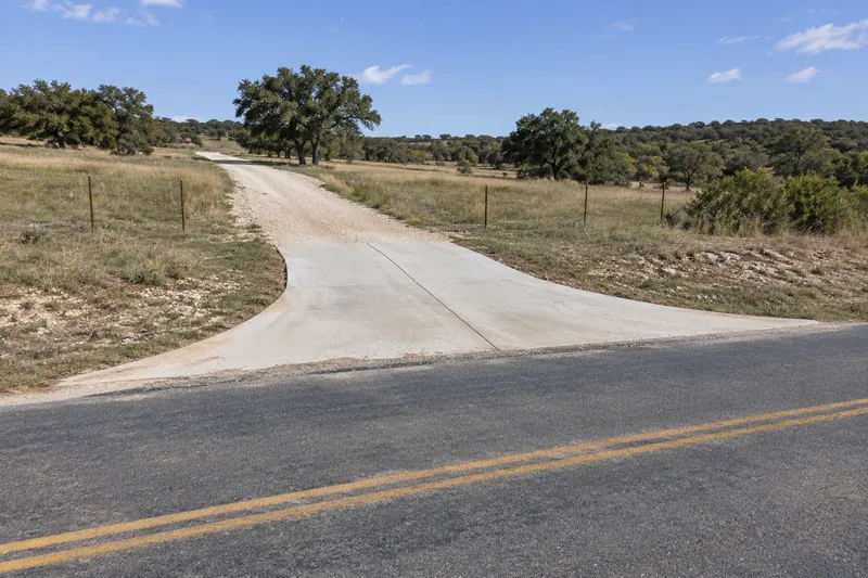 Concrete driveway approach meeting a two-lane rural road
