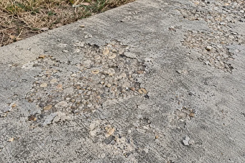 Scaled concrete surface with the top layer flaking away