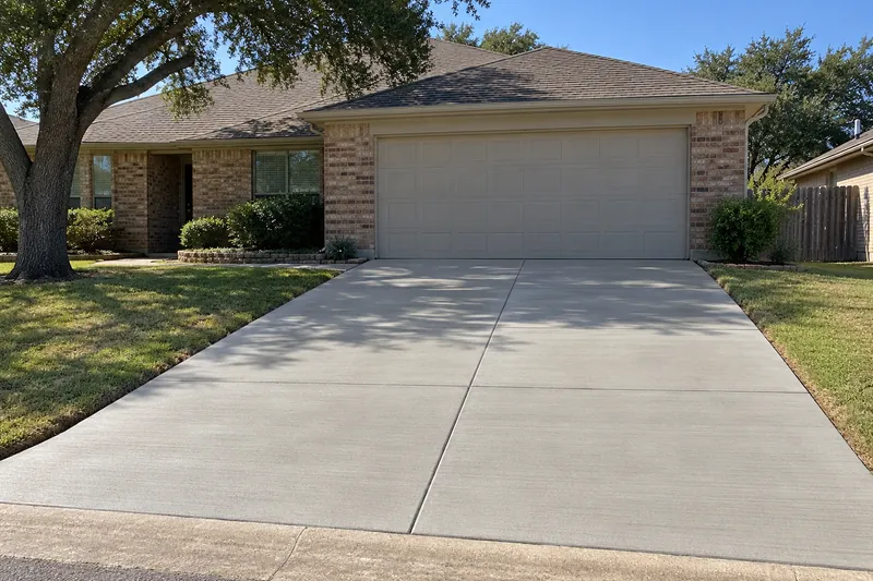 New two-car concrete driveway with a broom finish and sawn joints